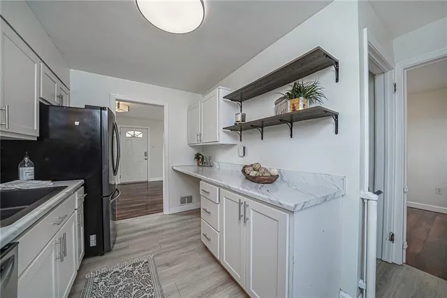 a kitchen with stainless steel appliances granite countertop a sink and a refrigerator