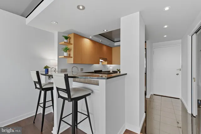 a kitchen with stainless steel appliances kitchen island granite countertop a refrigerator and a stove top oven