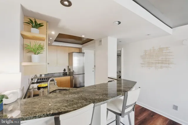 a kitchen with granite countertop a sink cabinets and wooden floor
