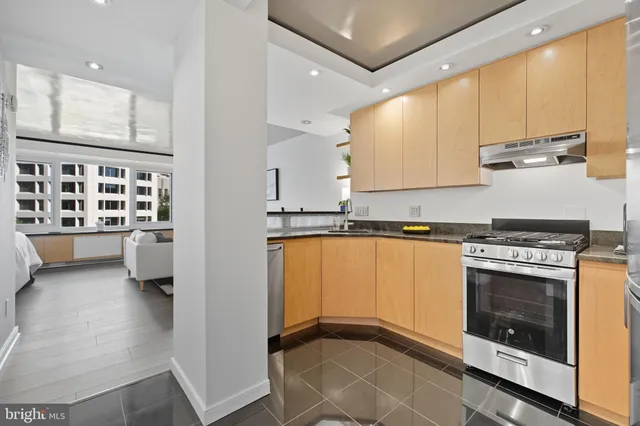 a kitchen with stainless steel appliances granite countertop a stove a sink and a refrigerator
