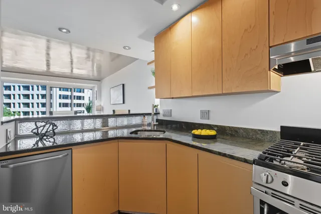 a kitchen with a sink a stove cabinets and a window