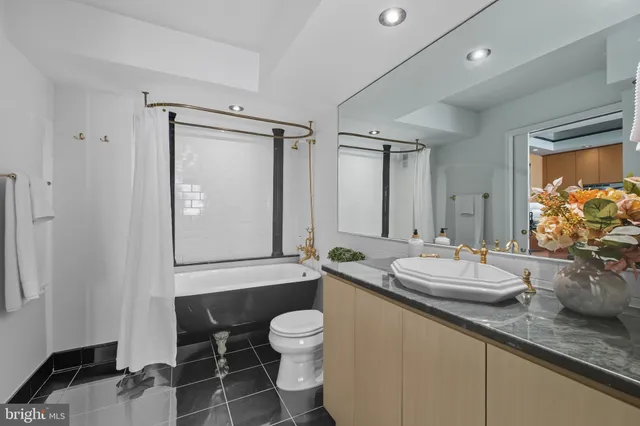 a bathroom with a granite countertop sink mirror and toilet