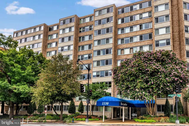 a front view of a building with lot of trees and barbeque oven