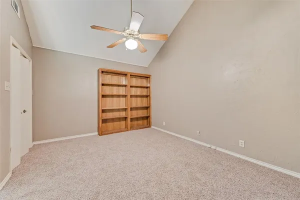 an empty room with windows and fan