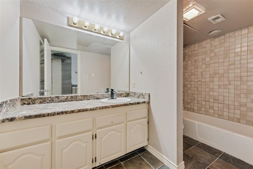 1242 Signal Ridge Place Rockwall, TX 75032 - Photo 19 of 27 a bathroom with a granite countertop sink mirror and a bathtub