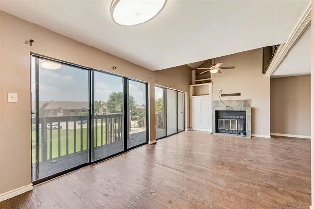 a view of an empty room with a fireplace and a large window