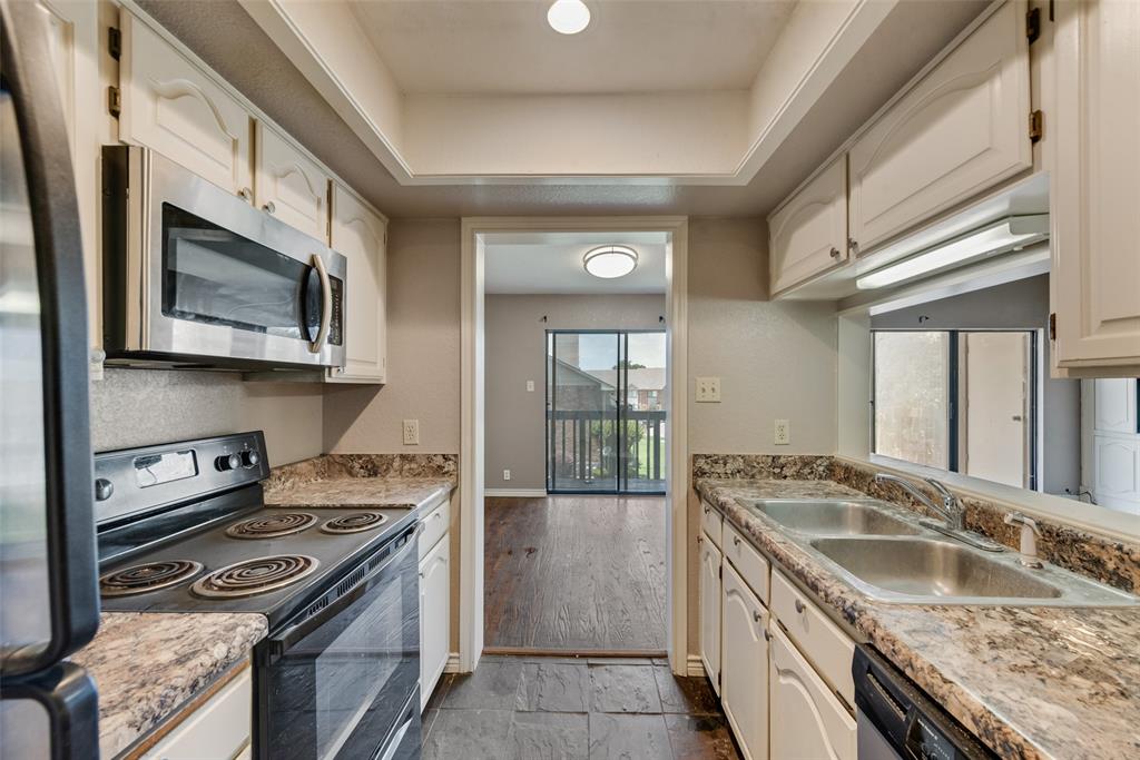 1242 Signal Ridge Place Rockwall, TX 75032 - Photo 7 of 27 a kitchen with stainless steel appliances granite countertop a sink stove and refrigerator