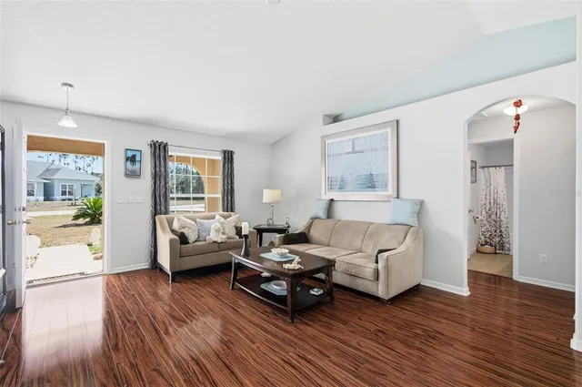 a kitchen with stainless steel appliances granite countertop a stove refrigerator and a dining table with wooden floor