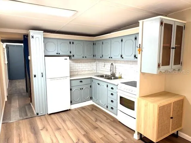 a kitchen with white cabinets and white appliances