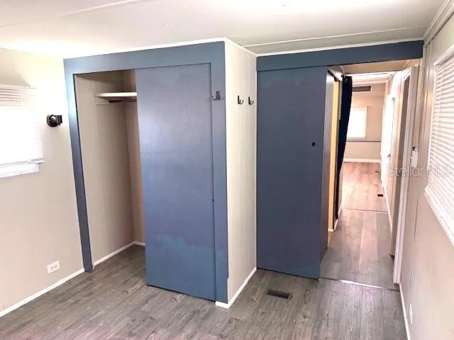 an empty room with wooden floor and a window