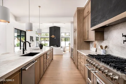 a kitchen with stainless steel appliances a sink a center island and windows