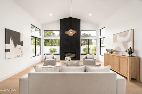 a living room with furniture a fireplace and a large window