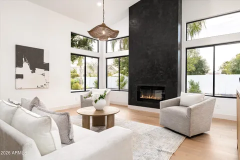 a living room with furniture kitchen view and a chandelier