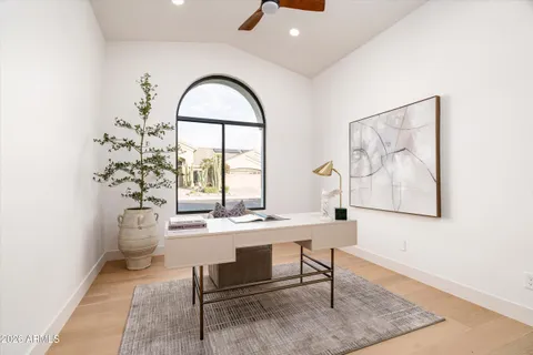 an empty room with windows and ceiling fan