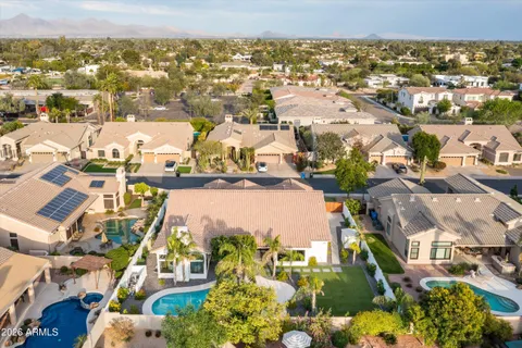 an aerial view of residential houses with outdoor space and parking