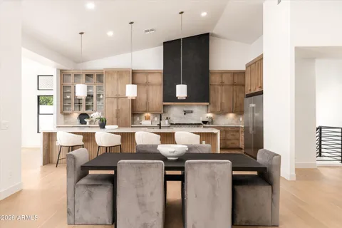 a kitchen with a sink stove and white cabinets with wooden floor