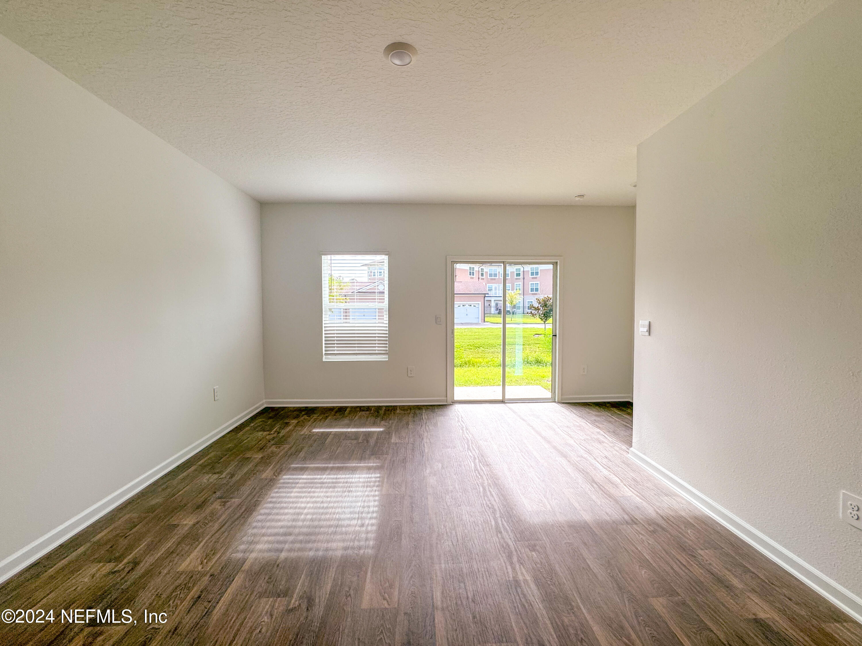 1633 Bridger Trace Middleburg, FL 32068 - Photo 12 of 26 a view of an empty room with a window and wooden floor