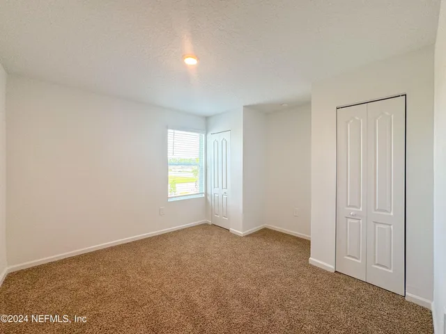 a view of a big room with wooden floor and windows