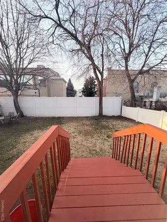 a view of wooden deck and a yard with trees