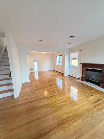 a view of empty room with wooden floor and fireplace