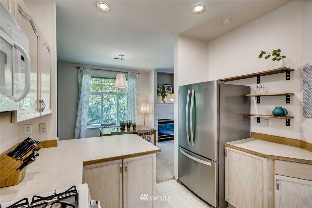 22715 4th Avenue West, Unit 104 Bothell, WA 98021 - Photo 11 of 27 a kitchen with stainless steel appliances a refrigerator sink and cabinets