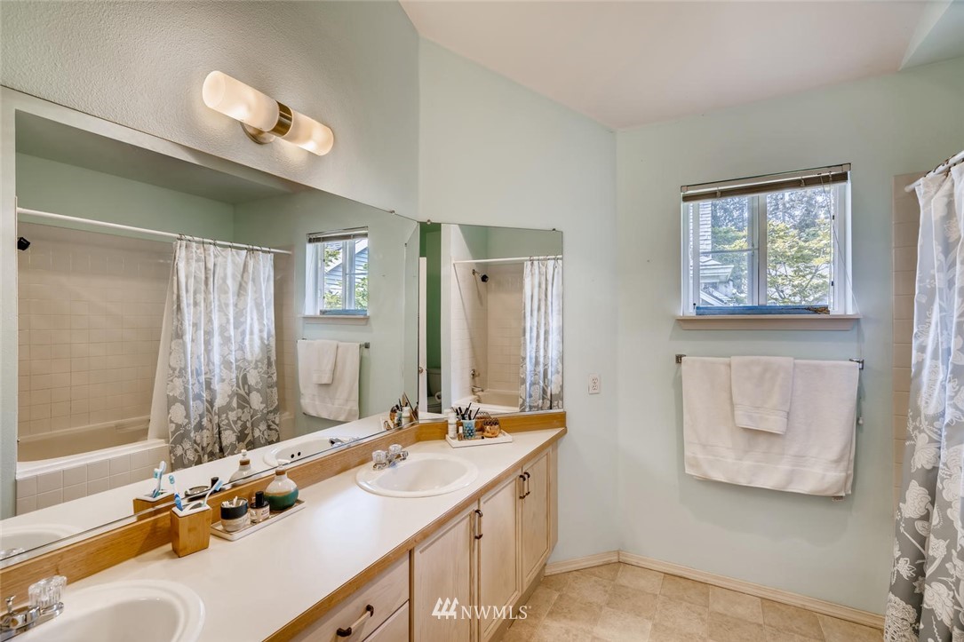 22715 4th Avenue West, Unit 104 Bothell, WA 98021 - Photo 16 of 27 a bathroom with 2 sink tub and a mirror