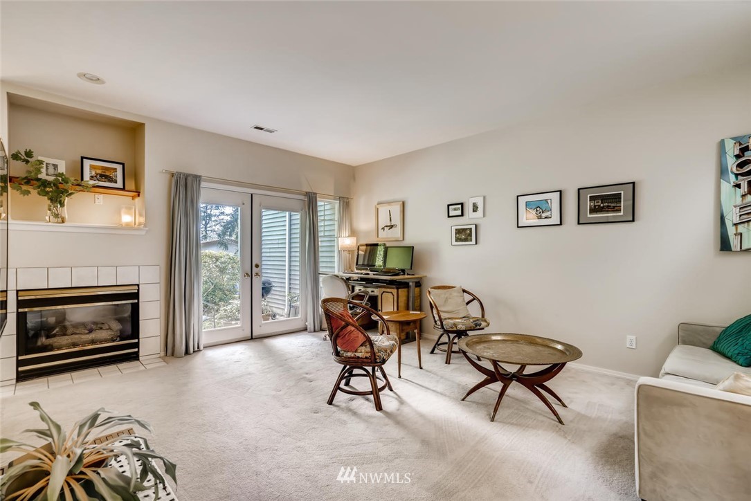 22715 4th Avenue West, Unit 104 Bothell, WA 98021 - Photo 4 of 27 a living room with furniture a fireplace and a flat screen tv