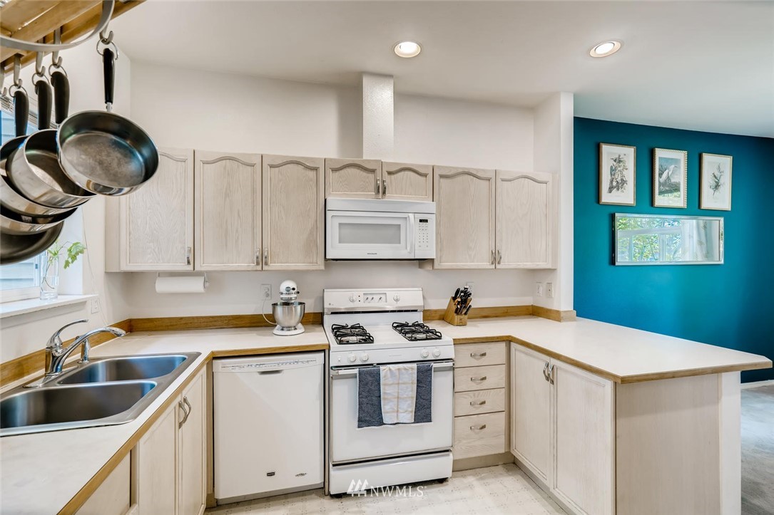 22715 4th Avenue West, Unit 104 Bothell, WA 98021 - Photo 8 of 27 a kitchen with white cabinets a sink and dishwasher