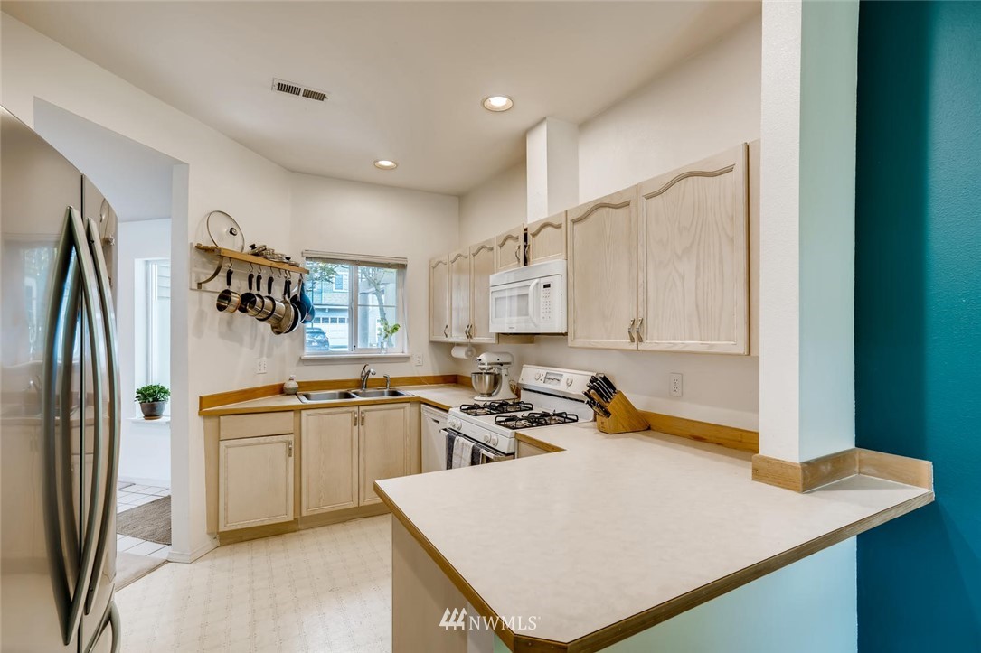 22715 4th Avenue West, Unit 104 Bothell, WA 98021 - Photo 9 of 27 a kitchen with stainless steel appliances granite countertop a sink stove and refrigerator