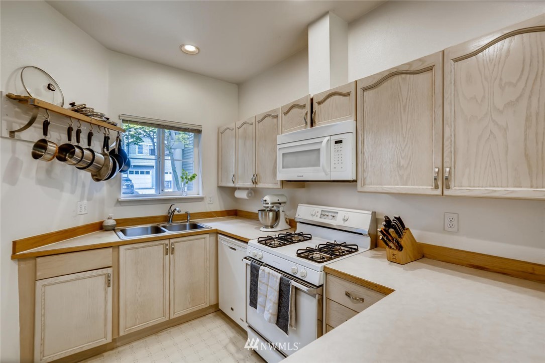 22715 4th Avenue West, Unit 104 Bothell, WA 98021 - Photo 10 of 27 a kitchen with stainless steel appliances granite countertop a sink stove and cabinets
