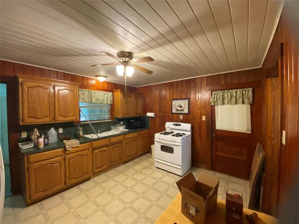 a large kitchen with cabinets table and chairs