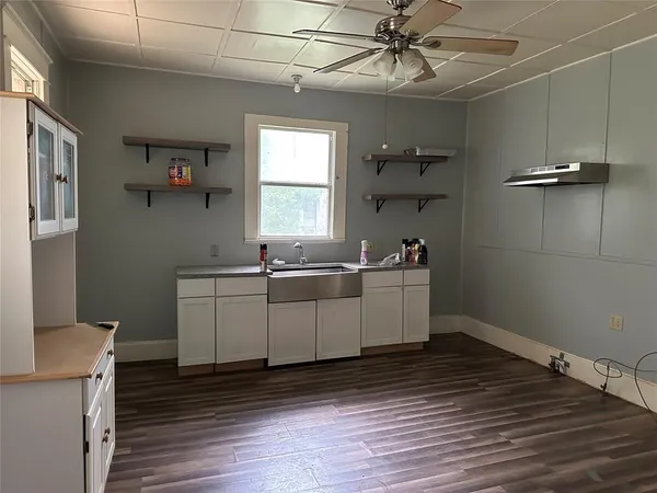 a view of a room with wooden floor and ceiling fan