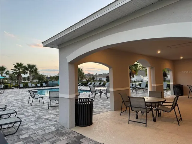 an empty room with wooden floor fan and window