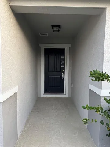 an empty room with wooden floor chandelier fan and windows