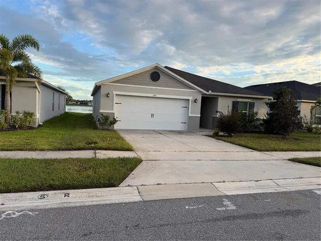 a front view of a house with a yard and garage
