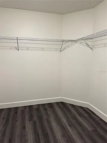 a view of an empty room with a floor to ceiling window and a ceiling fan