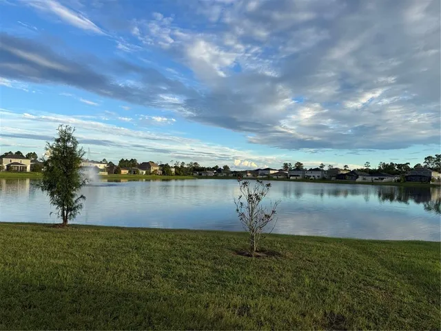 a front view of a house with a garden and trees