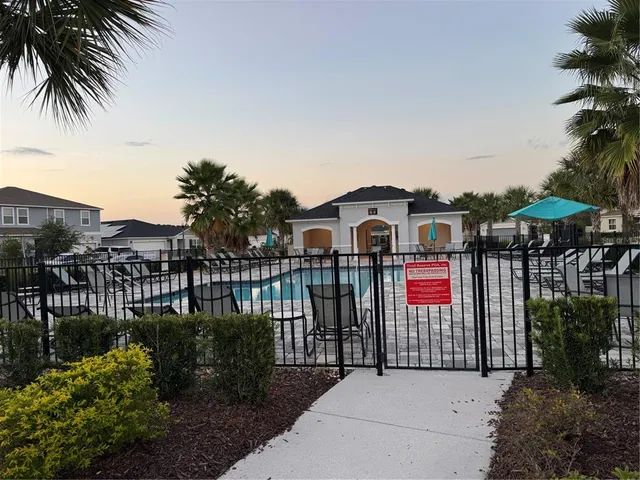 an empty room with wooden floor chandelier and windows