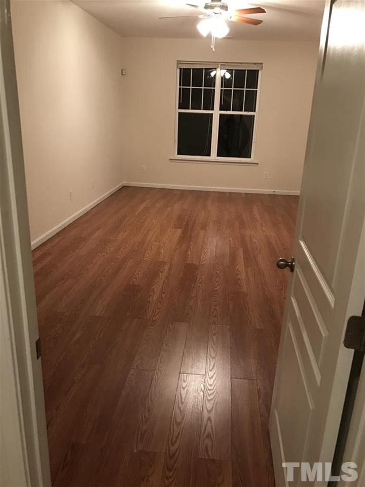 5010 Celtic Court Raleigh, NC 27612 - Photo 5 of 20 an empty room with wooden floor and windows