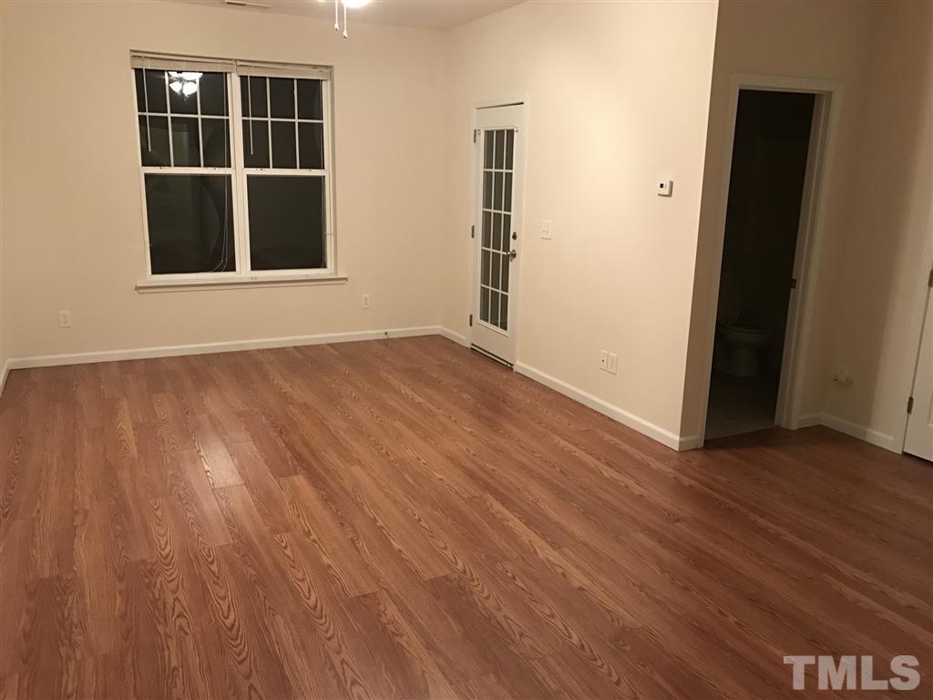 5010 Celtic Court Raleigh, NC 27612 - Photo 8 of 20 an empty room with wooden floor and windows