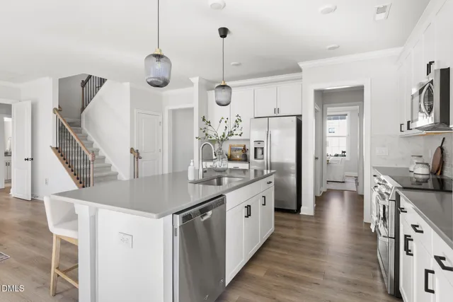 a kitchen with stainless steel appliances granite countertop a refrigerator a oven and a stove