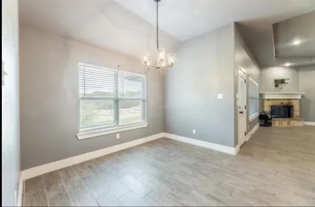 a view of a livingroom with a chandelier fireplace and window