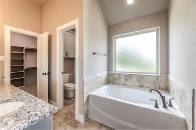 a bathroom with a granite countertop sink a mirror and a shower