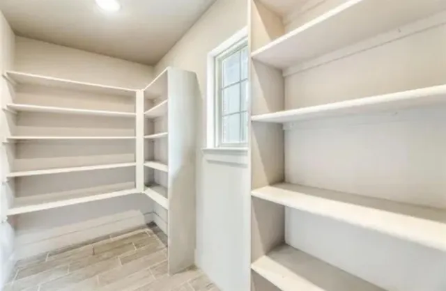 en empty room with windows and fireplace