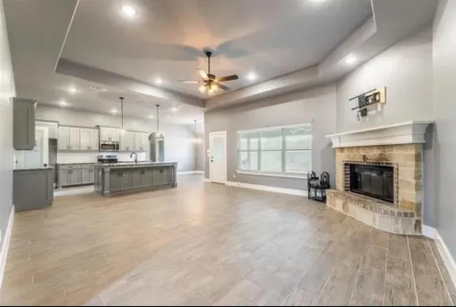 a view of an empty room with fireplace and a window