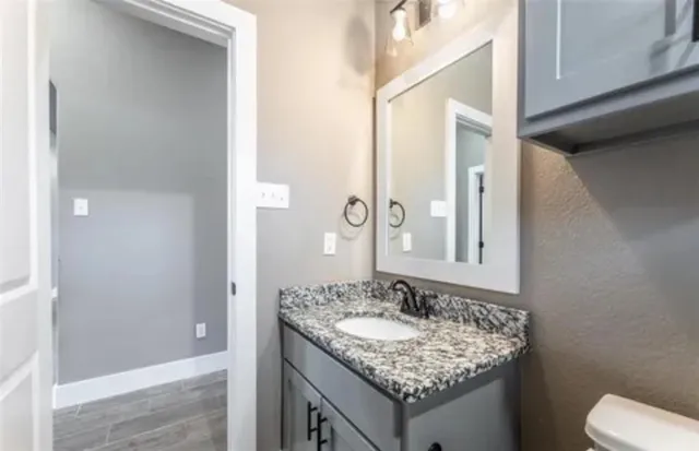 a bathroom with a granite countertop sink and a mirror