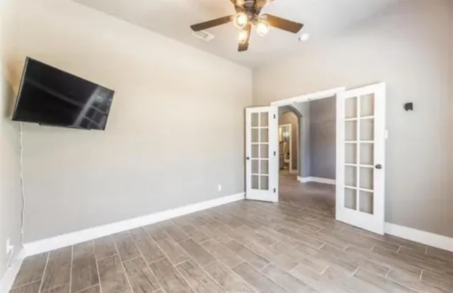 en empty room with wooden floor and ceiling fan