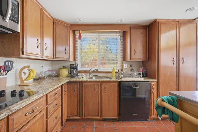 a kitchen with stainless steel appliances granite countertop a sink a stove and a refrigerator