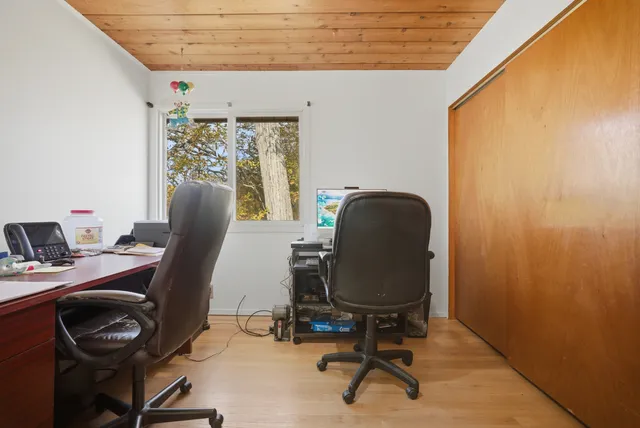 a view of a workspace with furniture and a window