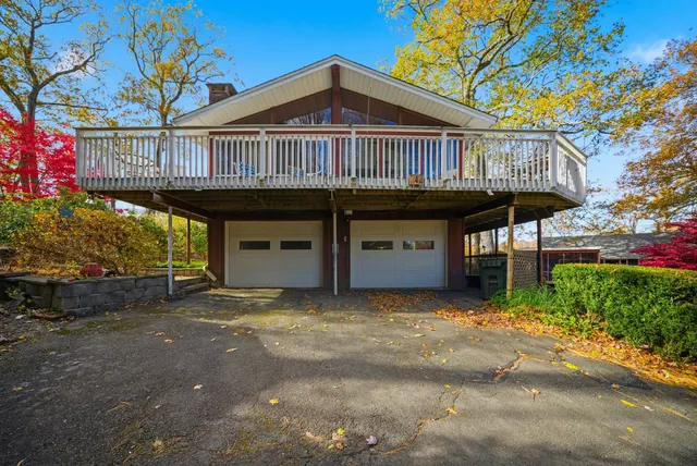 a view of a house with large windows and a small yard